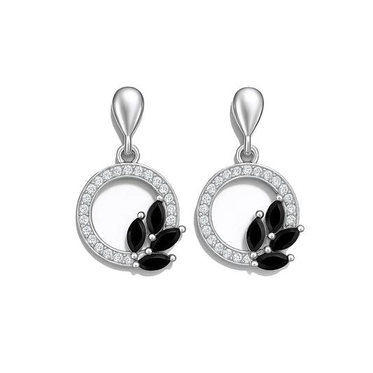 Pair of silver earrings with black stones on a white background
