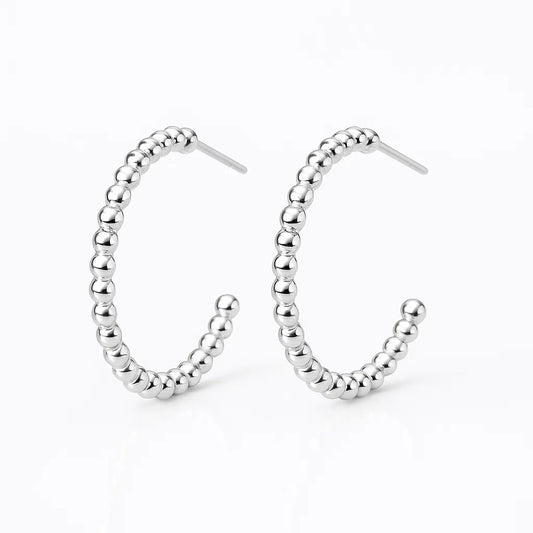 Silver beaded hoop earrings on a white background
