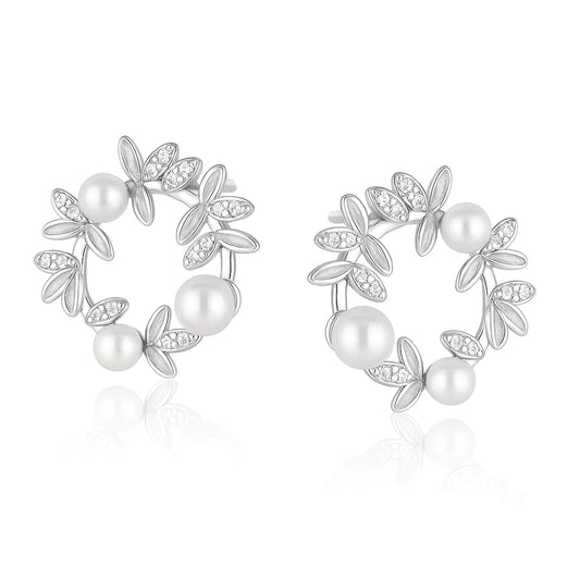 Pair of silver earrings with pearls and leaf-like designs on a white background